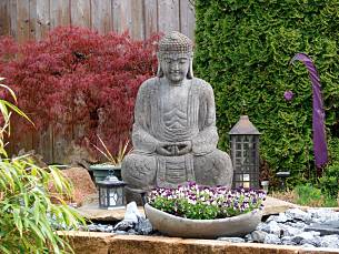Augen zu und mitlächeln: Buddha meditiert über die Hornveilchen-Gesellschaft in der Schale.